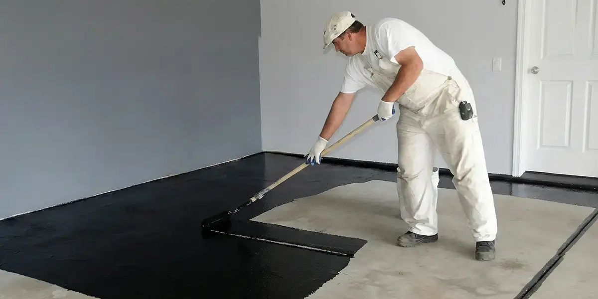 basement waterproofing professional applying waterproof coating to protect a basement floor in Baton Rouge, LA